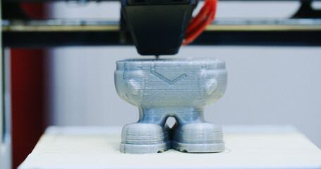 Closeup shot of a 3D printer in the process of printing a polymer element - 707864303