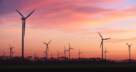Windmill generating green energy by sunset at Neusiedl Weiden wind park in Austria - 707864323
