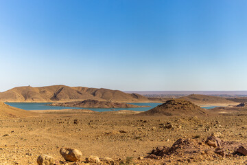 Turquoise blue water in Barrage Al-Hassan Addakhil in dry nature near Errachidia in Morocco.