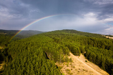 Dramatic Summer Storm Aerial Photo of a Mountain Fores with a Rainbow - 707865717