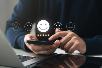 customer satisfaction survey concept, businessman use smartphone Touch the happy smiley icon....