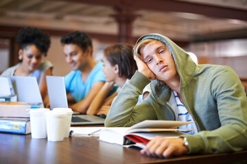 Tired, study group or portrait of student in library with burnout, depression or low energy. Lazy man, university or exhausted person bored by books with fatigue or adhd with people for teamwork