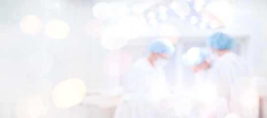 Abstract medical blurred background of operating room, patient lies on table, doctors working...