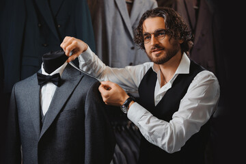 Italy young man tailor fitting bespoke suit to men in atelier or tailoring studio. Concept fashion...