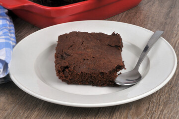 Part de brownie fait maison dans une assiette avec une cuillère en gros plan