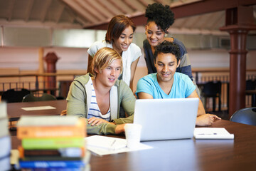 Teamwork, laptop or group of students studying in university, college or school campus for education. Library, elearning or happy people with scholarship, reading news, research or online course