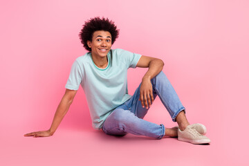 Full length photo of handsome young male sit floor posing have rest dressed stylish blue garment isolated on pink color background