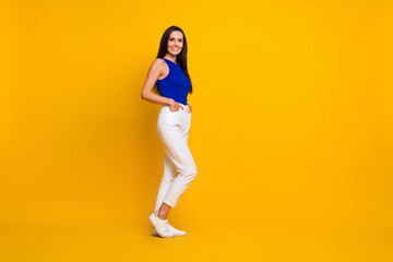 Full length photo of pretty adorable lady dressed blue top smiling empty space isolated yellow...