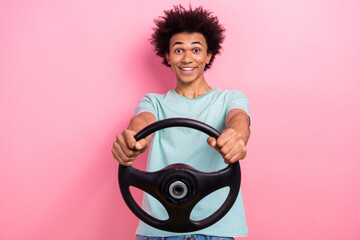 Photo of good mood cheerful man dressed blue t-shirt riding automobile isolated pink color...