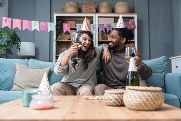Simple living. Happy young couple celebrate birthday, having party at their new apartment, started...