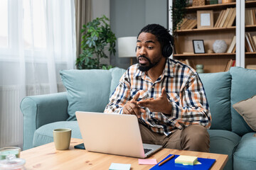 Young African American man healthcare worker psychologist psychotherapist talking online on web conference video call about how to reduce stress and anxiety in everyday life. Male expert home office - obrazy, fototapety, plakaty