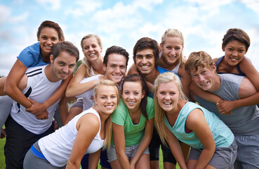 Group, friends and happy on field with portrait for fitness, sport and exercise with collaboration. Teamwork, men and women with face, smile or blue sky outdoor in nature for workout or training