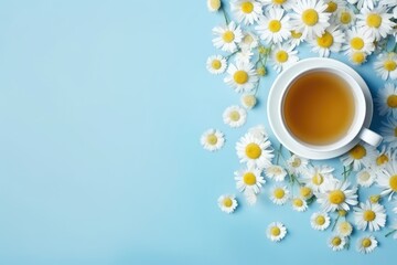 Steaming chamomile tea in a white cup on a blue background, resembling a flat lay.
