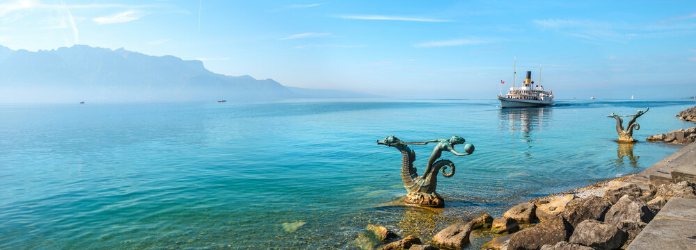 Landscape with mermaid sculptures in water on coastline of riviera Lake Geneva at Vevey town. Switzerland