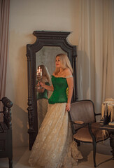 Medieval romantic style. Woman in evening beige dress and green silk corset