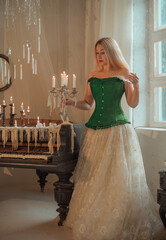 Medieval romantic style. Woman in evening beige dress and green silk corset