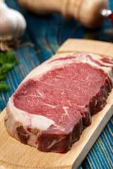 Raw meat on cutting board with spices on wooden background