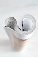 Rolled up magazine, newspaper, selective and shallow focus, white background,copy space - 707931556