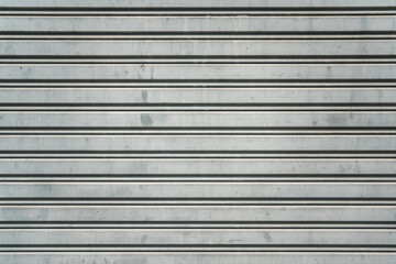Obraz premium Closed metal grate rolling door of the warehouse storage or service garage.