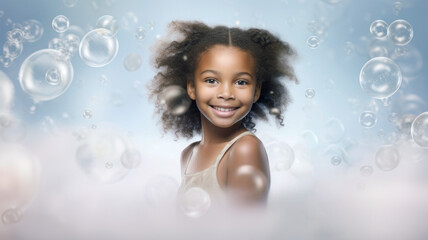 Fototapeta premium Happy little girl in the bathtub covered in soap bubbles, laughing. A close-up portrait of a smiling child.