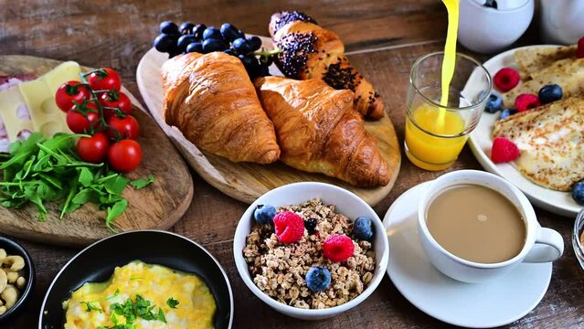 Breakfast served with coffee, orange juice, scrambled eggs, cereals, pancakes and croissants.