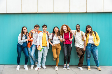 Diverse college students standing together on a blue wall - Photo portrait of multiracial teenagers in front of university building - obrazy, fototapety, plakaty