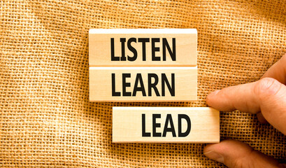 Listen learn lead symbol. Concept word Listen Learn Lead on beautiful wooden block. Businessman...