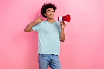 Photo of cool confident guy wear blue t-shirt screaming toa empty space showing thumb up isolated pink color background