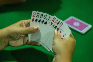 Mão feminina segurando cartas de baralho, foto feita em são paulo em 04 janeiro 2024 - obrazy, fototapety, plakaty