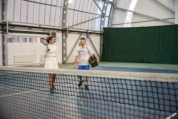 Cheerful man and woman after playing game of tennis at
