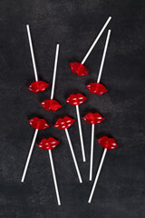 Holiday Red lips lollipops on a paper stick. Dark background. Top view. Valentine's day