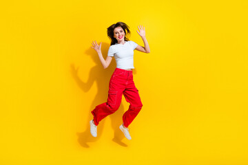 Fototapeta na wymiar Full length photo of funky good mood woman dressed white t-shirt jumping high isolated yellow color background