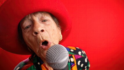 Funny closeup fisheye view of elderly woman singing enthusiastically into a microphone and dancing...