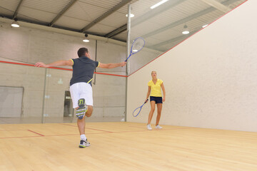 couple playing squash on indoor court