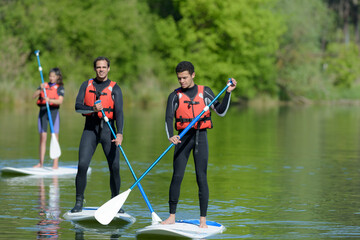 2 men on a stand up paddle board