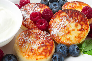 breakfast, cottage cheese cakes, with fresh berries, and sour cream, top view, close-up, no people,