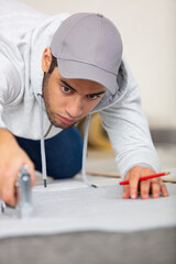a young man is stapling an insulating layer to floor