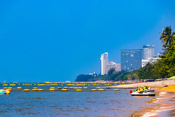 Tropical beach waves sand people boat palm trees Pattaya Thailand.