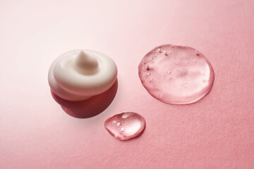 Gel, serum and a cream on a pink background.