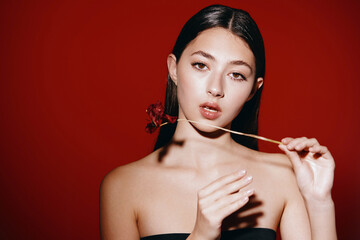 Stunning Asian Lady with Perfect Hair and Glamorous Make-up in Elegant Red Dress on White Studio Background