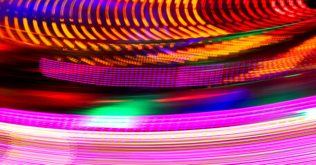 Moving lights of a Merry-go-round or carousel with colorful red, yellow, pink and orange...