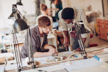 Two young male architects working on project in office