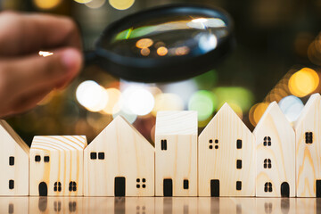 Magnifying glass and house model, house selection, real estate concept.	