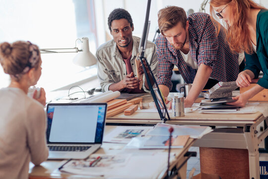 Diverse young people collaborating on a project in a modern workspace