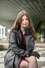 selbstbewusste junge Frau mit schwarzem Mantel