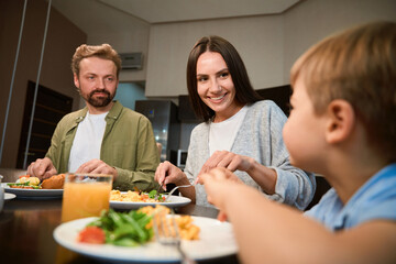 Cheerful family enjoying weekend breakfast together during Christmas celebration