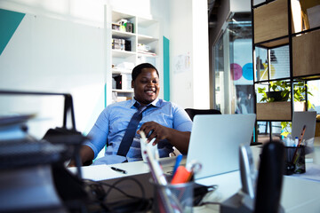 Young black businessman working on office laptop