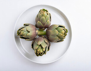 Obraz premium Carciofo a spicchi e intero in un piatto bianco