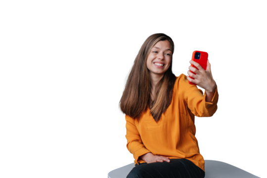 Adorable brunette young woman against transparent background holding phone making video call looking at screen. Beautiful housewife making selfie. Happy women.