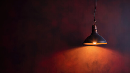 Obraz premium A lamp hangs against a dark wall, casting its light and illuminating the area, with space available for text or presentation.